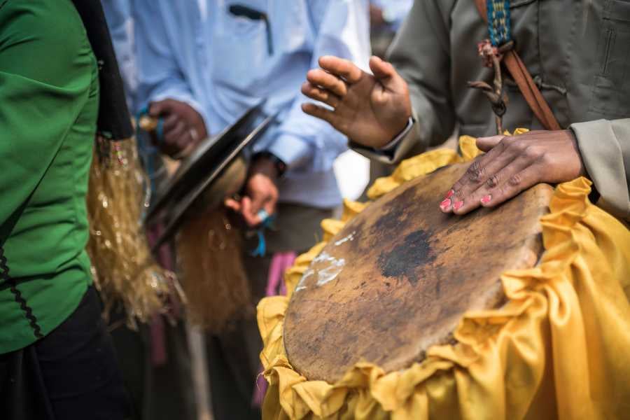 Close-up of hands playing traditional drums in a lively rhythm.