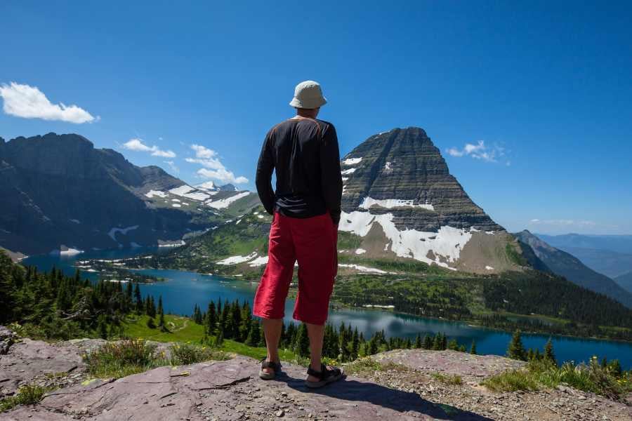  A lone hiker admiring breathtaking alpine scenery from a high vantage point.