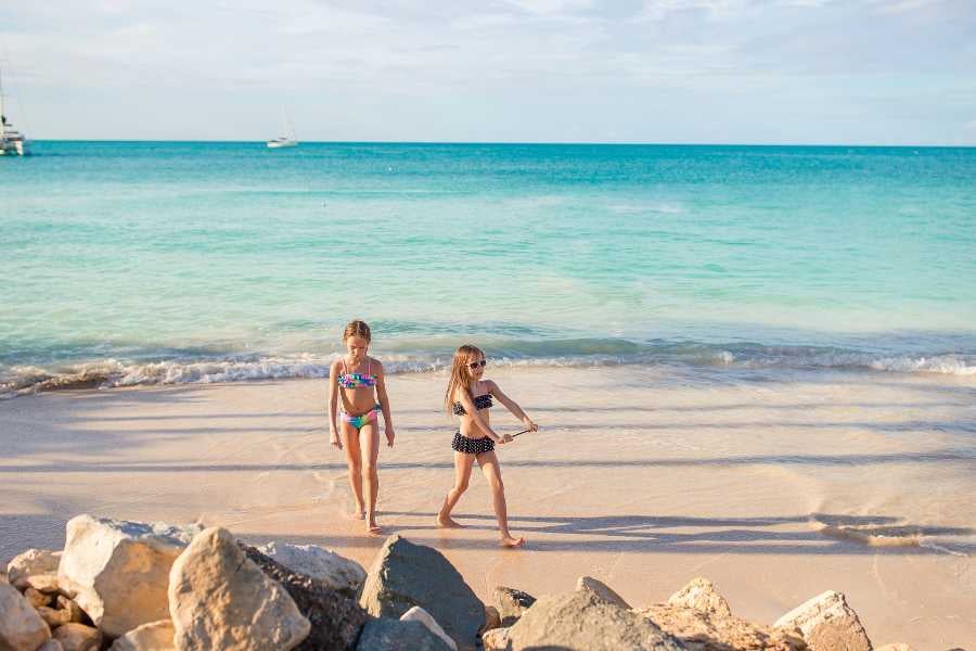 Two girls are walking on the beach sand