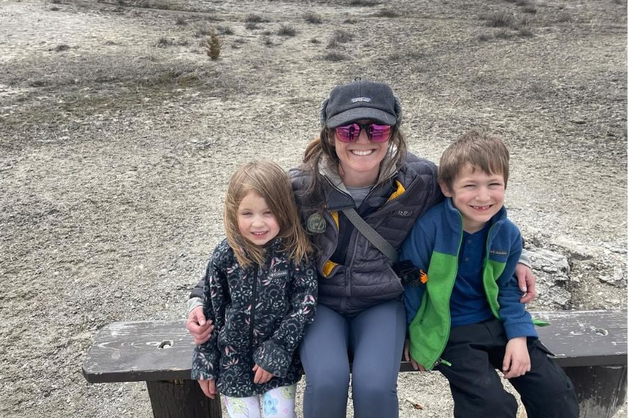 Mom and kids smiling together on a Yellowstone hike.