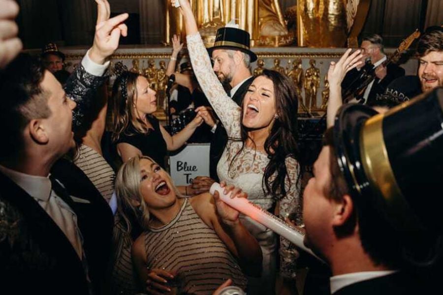 A bride and guests celebrate with music and dancing in a stunning temple hall.