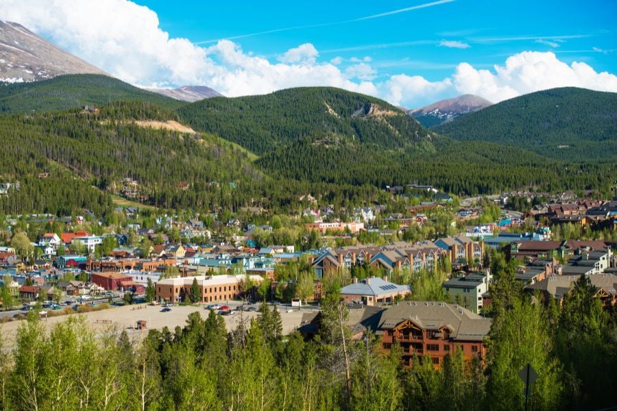 Breckenridge&rsquo;s colorful mountain town shines between green hills and tall peaks.