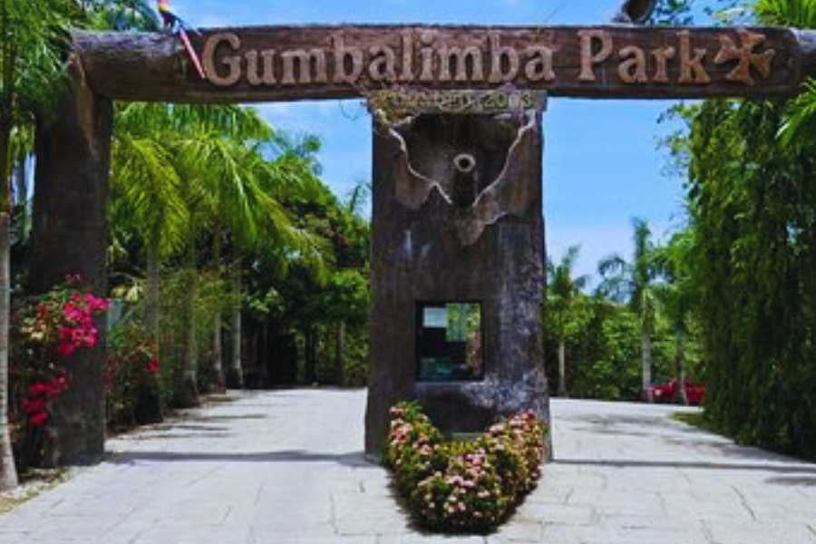 A lush entrance to Gumbalimba Park, featuring tropical greenery and a welcoming sign.