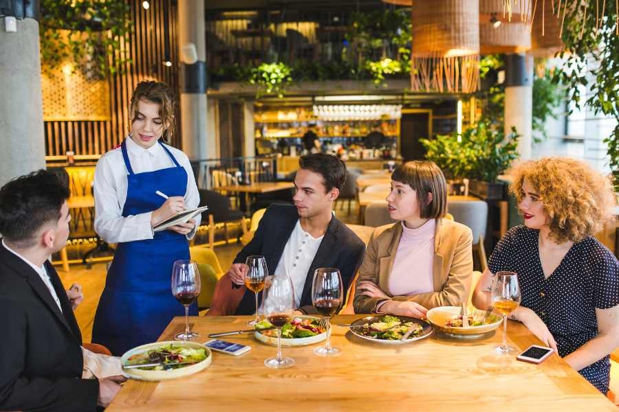 Friends chat over wine in a modern restaurant.