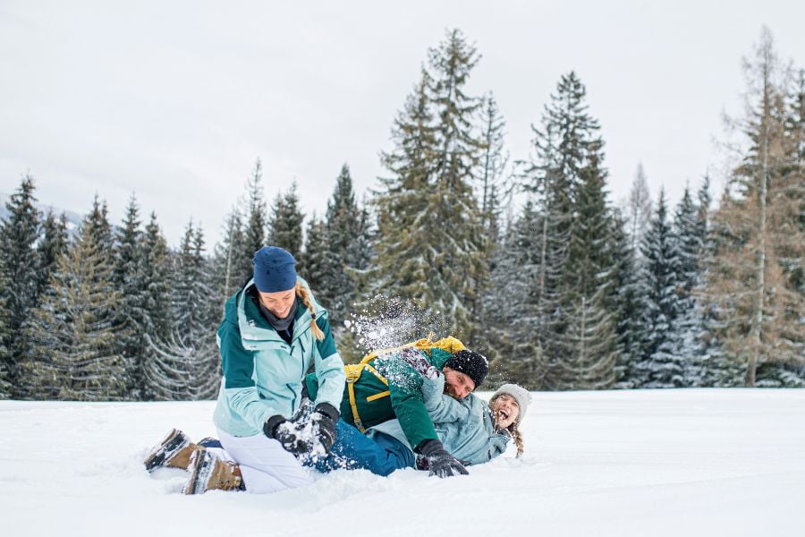 Friends laughing and playing in the snow in Vail.