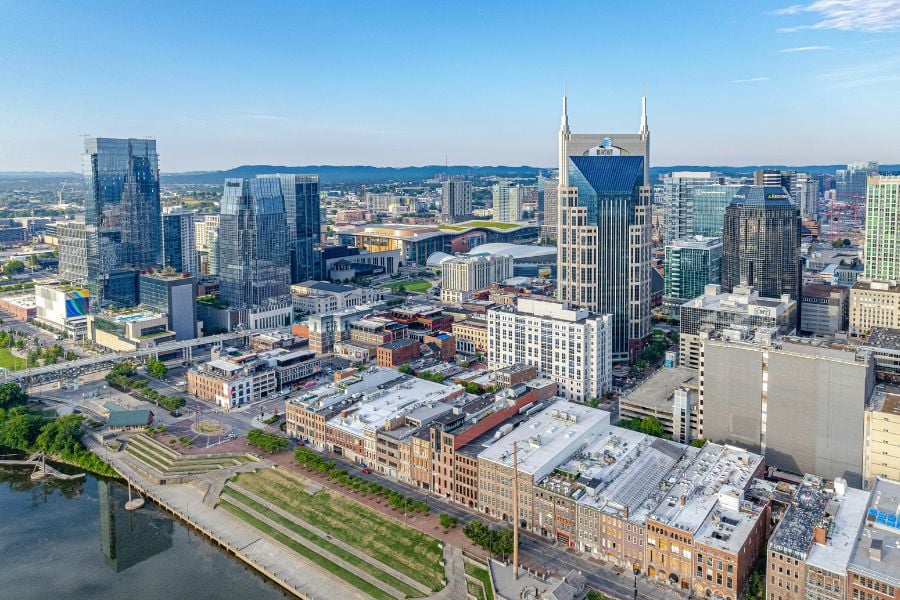 A sunny view of Nashville’s downtown skyline with tall buildings and busy streets.