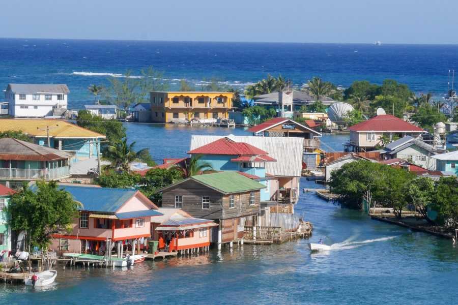 A lively seaside village with colorful houses and waterways offers a picturesque Caribbean escape.