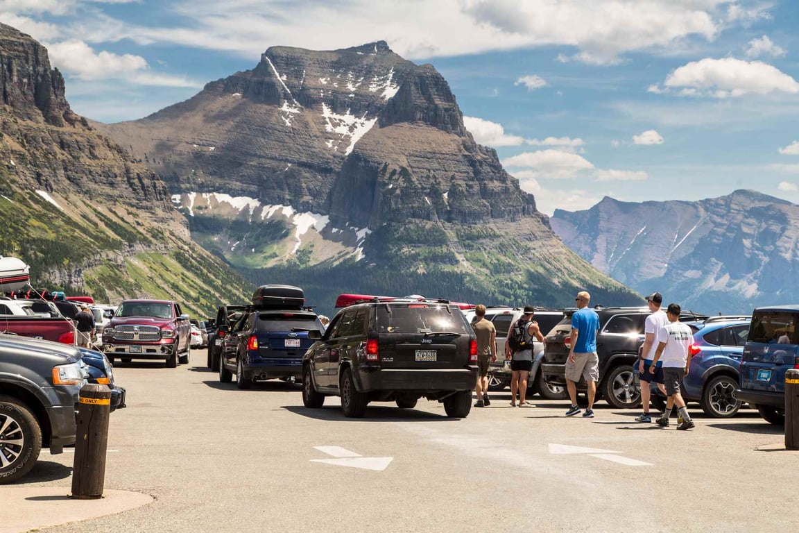 visitors in a crowded parking lot at glacier national park