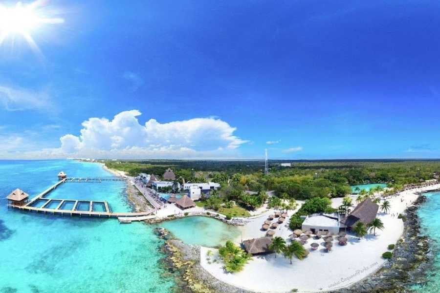 A breathtaking aerial view of a beachside resort with crystal-clear waters, sandy shores, and lush greenery.