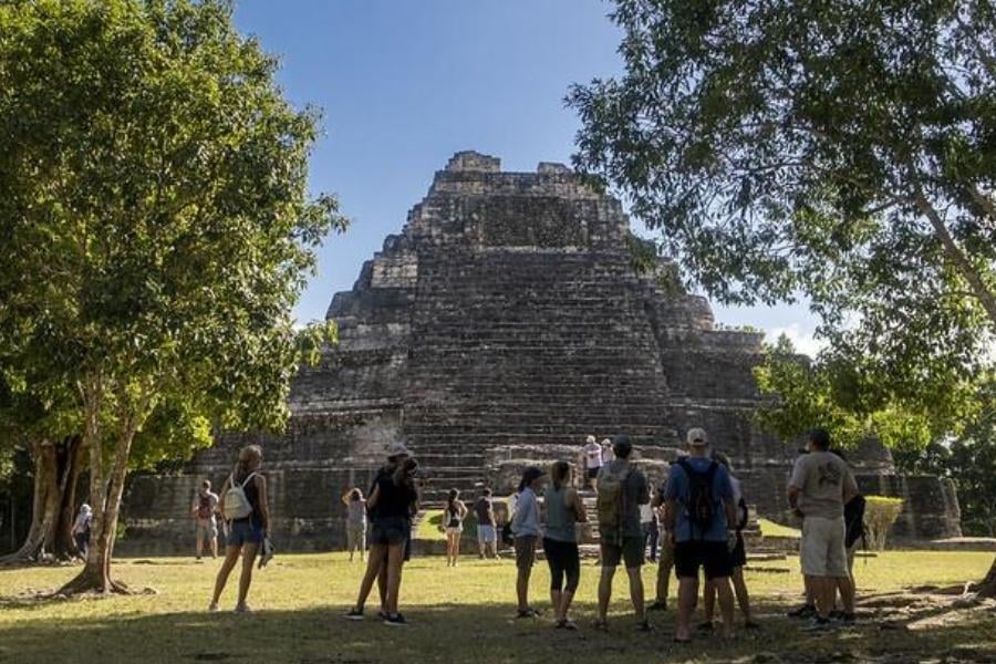 Tourists gather near a majestic pyramid, ready to delve into the mysteries of Mayan civilization.