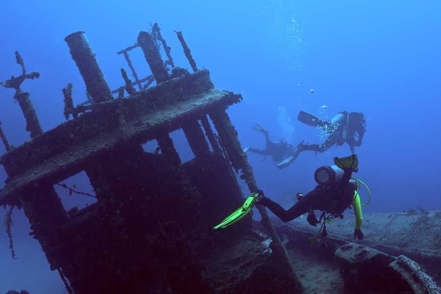 Diver looking at the wreck of a ship