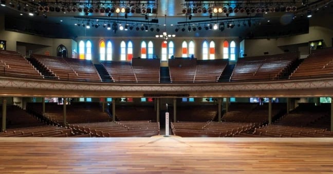 Interior view of Ryman Auditorium with wooden pews and stained glass windows