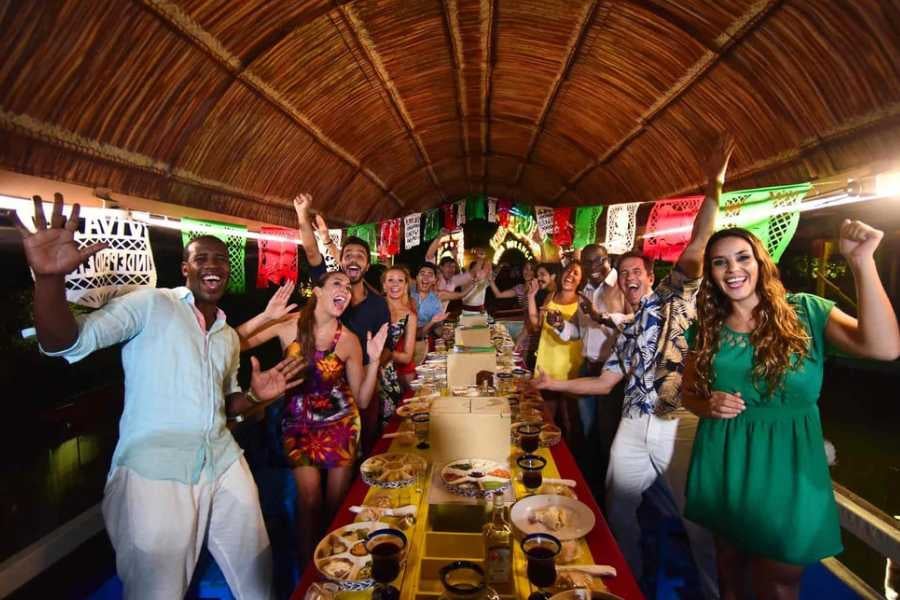 Guests laughing and feasting together on a vibrant boat decorated with festive Mexican themes.