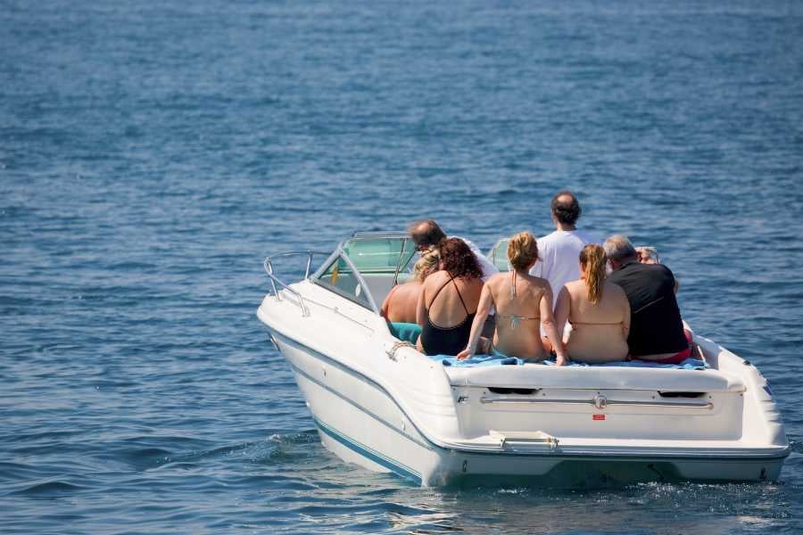 Friends enjoy a sunny day cruising the ocean in a sleek speedboat.