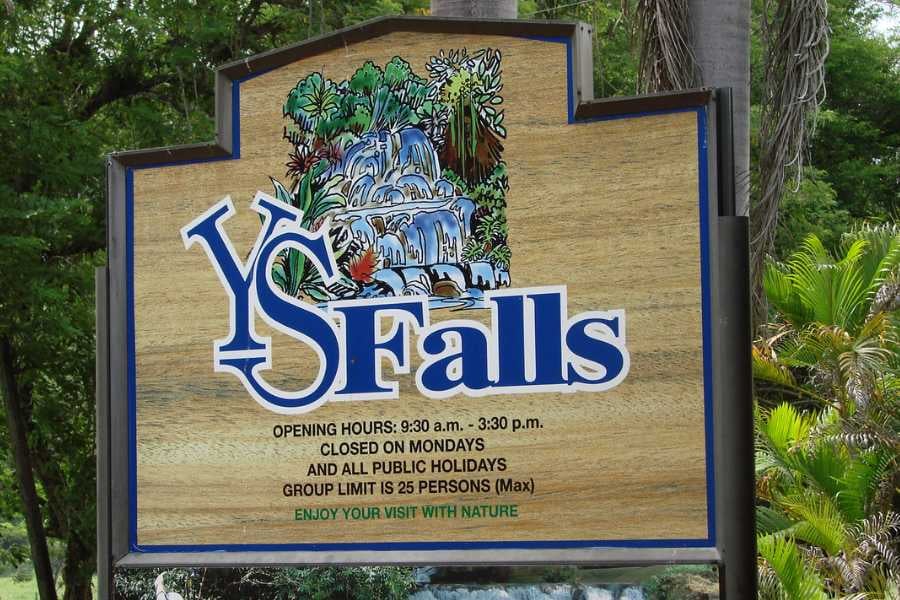 A wooden sign welcomes visitors to the beautiful YS Falls.