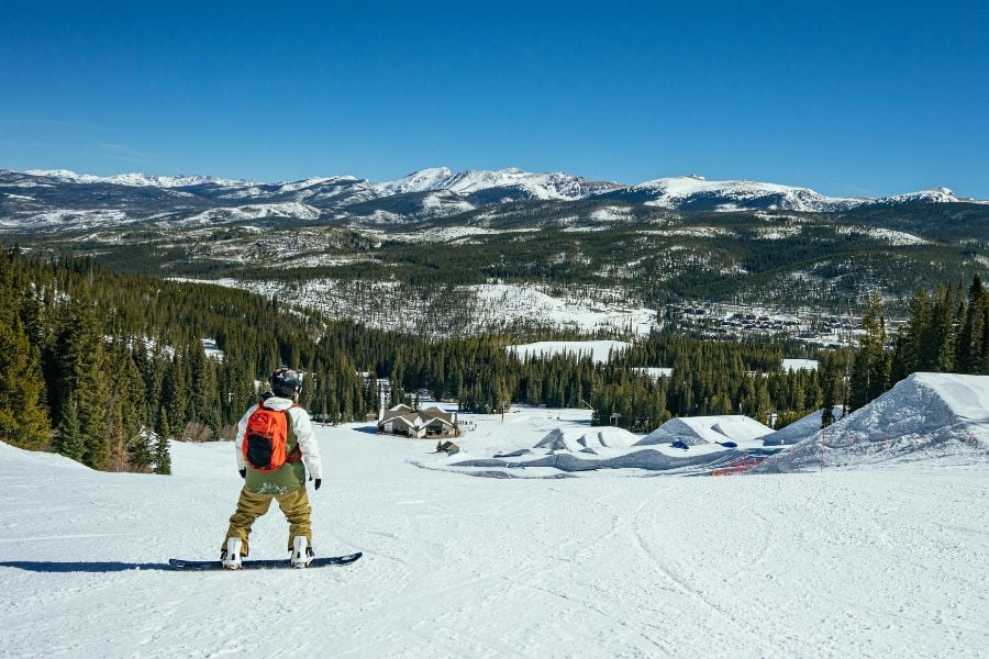 Snowboarder enjoying a clear day on the mountain slopes.