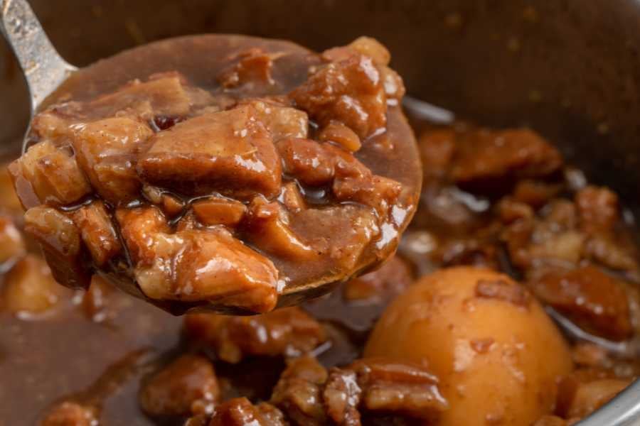 A tasty stew with chunks of meat and a boiled egg in a thick, flavorful sauce.