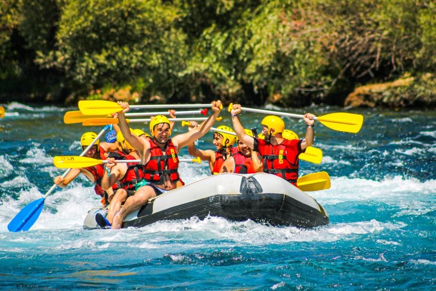 Rafters crash through whitewater as the raft leaps over a rapid.