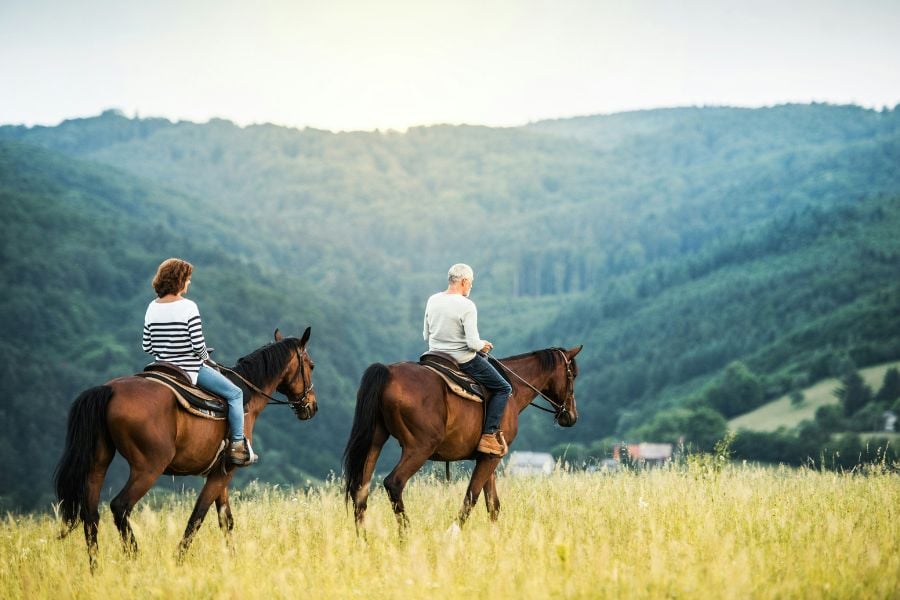 Two riders enjoy a peaceful horseback ride through Breckenridge&rsquo;s mountain meadows.