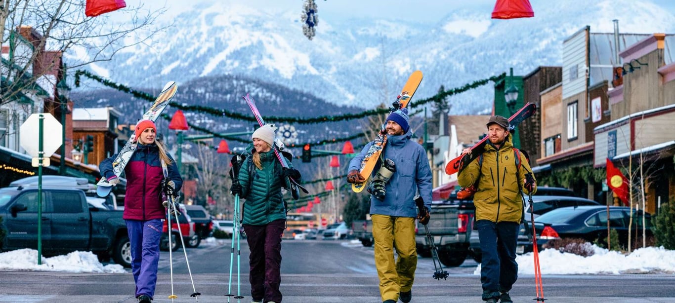 a group of skiers walking down the street