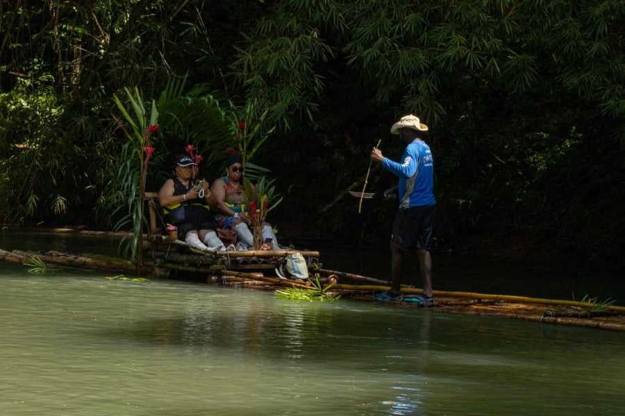 Guests enjoy a peaceful bamboo rafting trip through lush jungle.