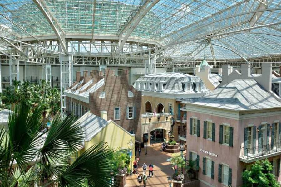 A charming indoor street under a glass roof at Opryland Hotel & Resort, lined with shops and greenery.