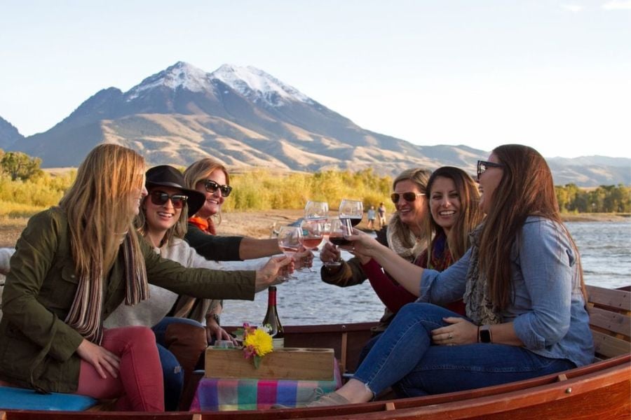 Group of friends toasting wine while relaxing on a river boat.