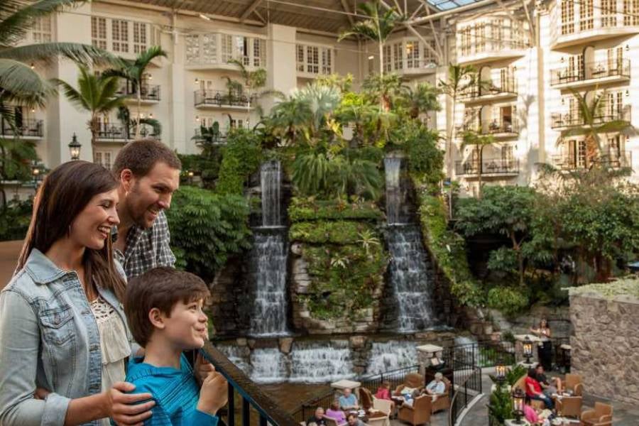 A family enjoys the view of waterfalls and lush indoor gardens at Opryland Hotel & Resort.