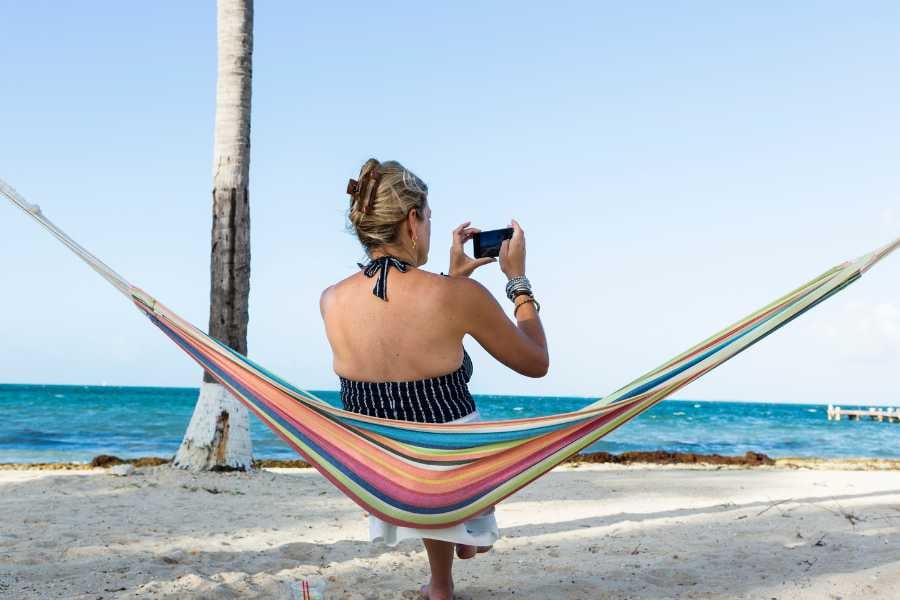 A woman captures a photo of the beach on her mobile phone