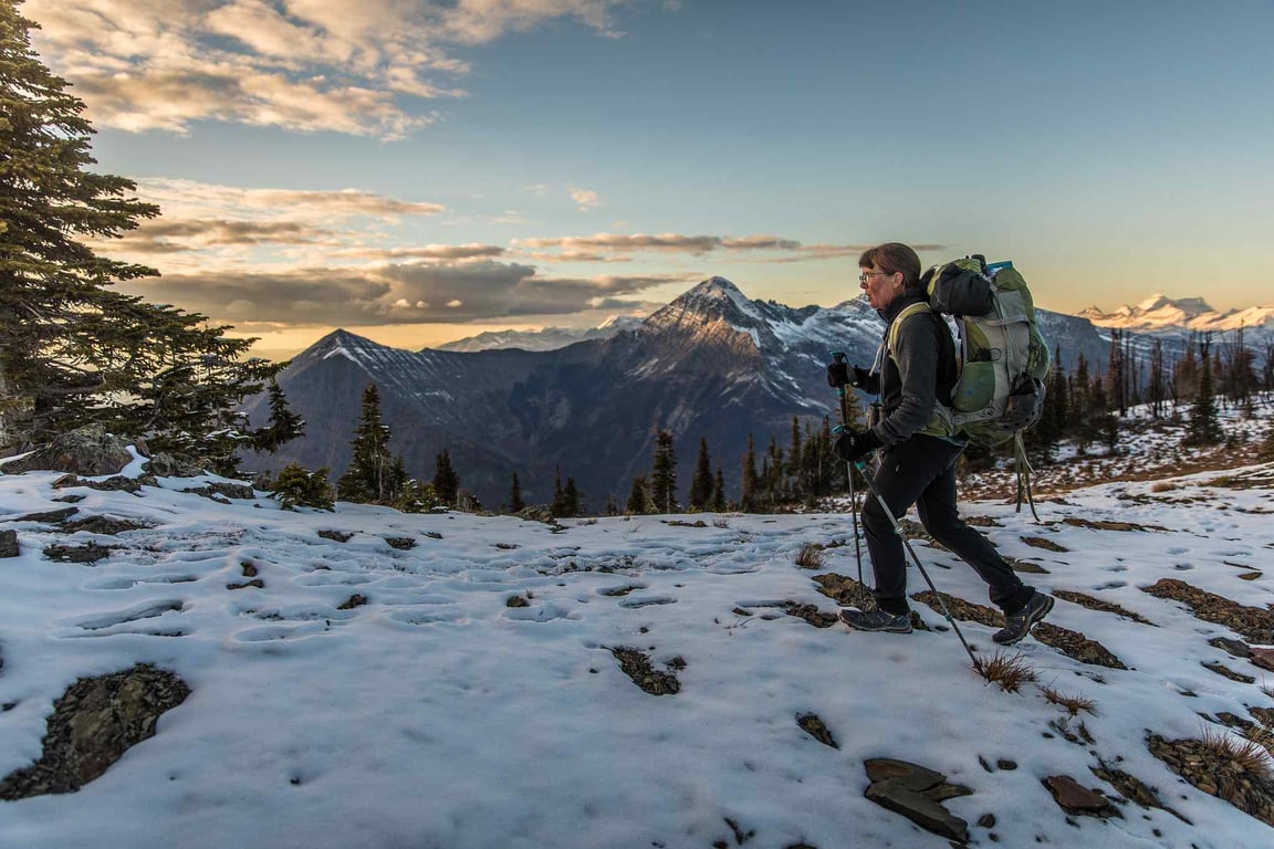 woman hiking in a snowy Glacier National Park