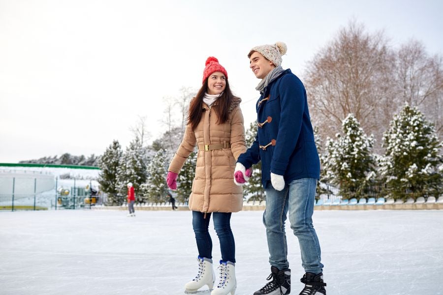 People enjoying ice skating on a snowy outdoor rink in Breckenridge.