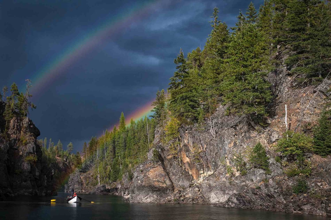 Angler casting a fly rod on the Middle Fork of the Flathead River during a guided drift boat fly fishing trip near Glacier National Park