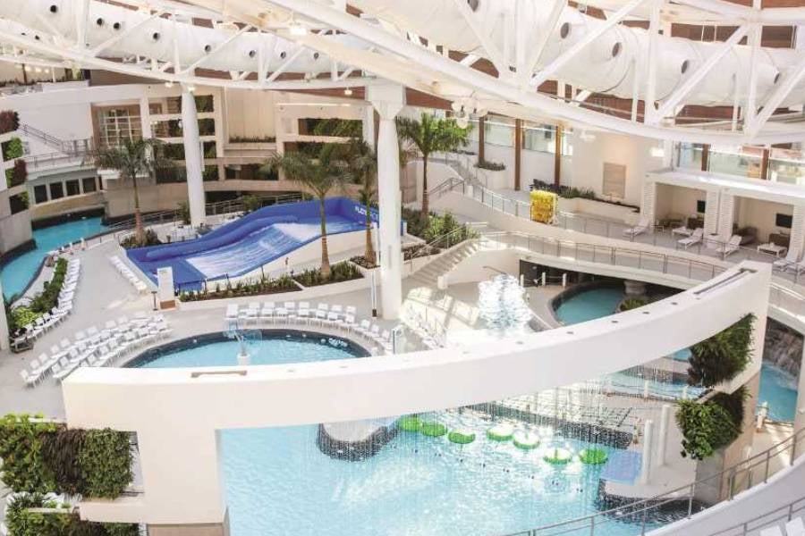The indoor water park at Opryland Hotel & Resort features pools, palm trees, and a FlowRider surf simulator.
