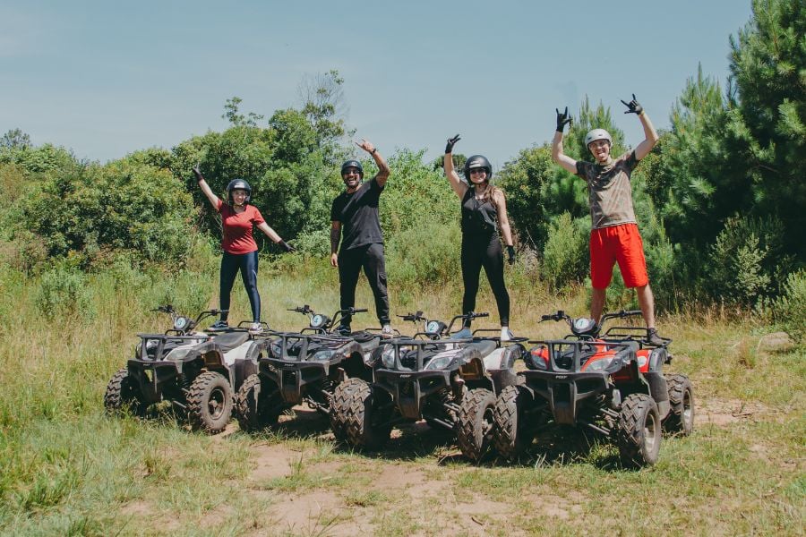 Friends posing proudly on ATVs, ready for off-road fun.