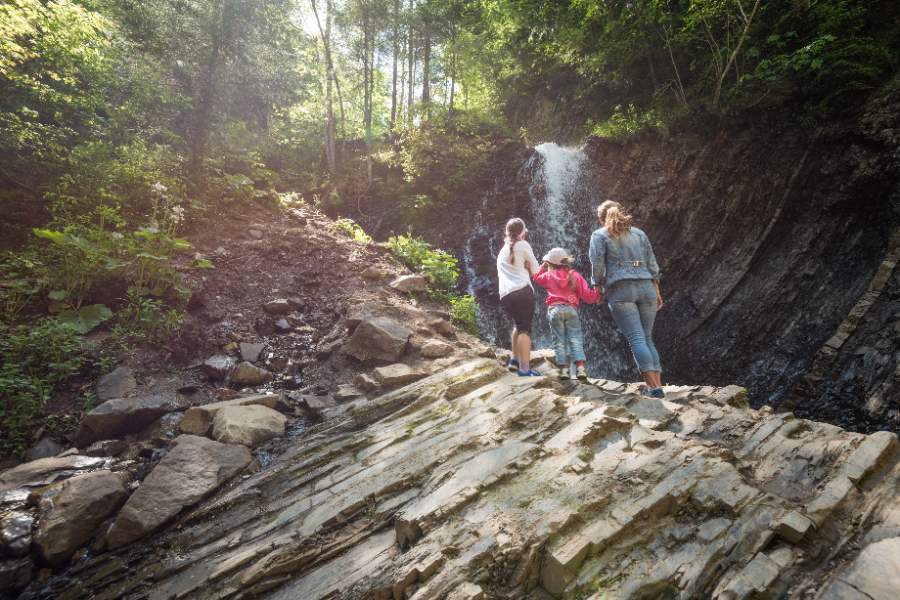 A woman with her children watching the beautiful view of the waterfall