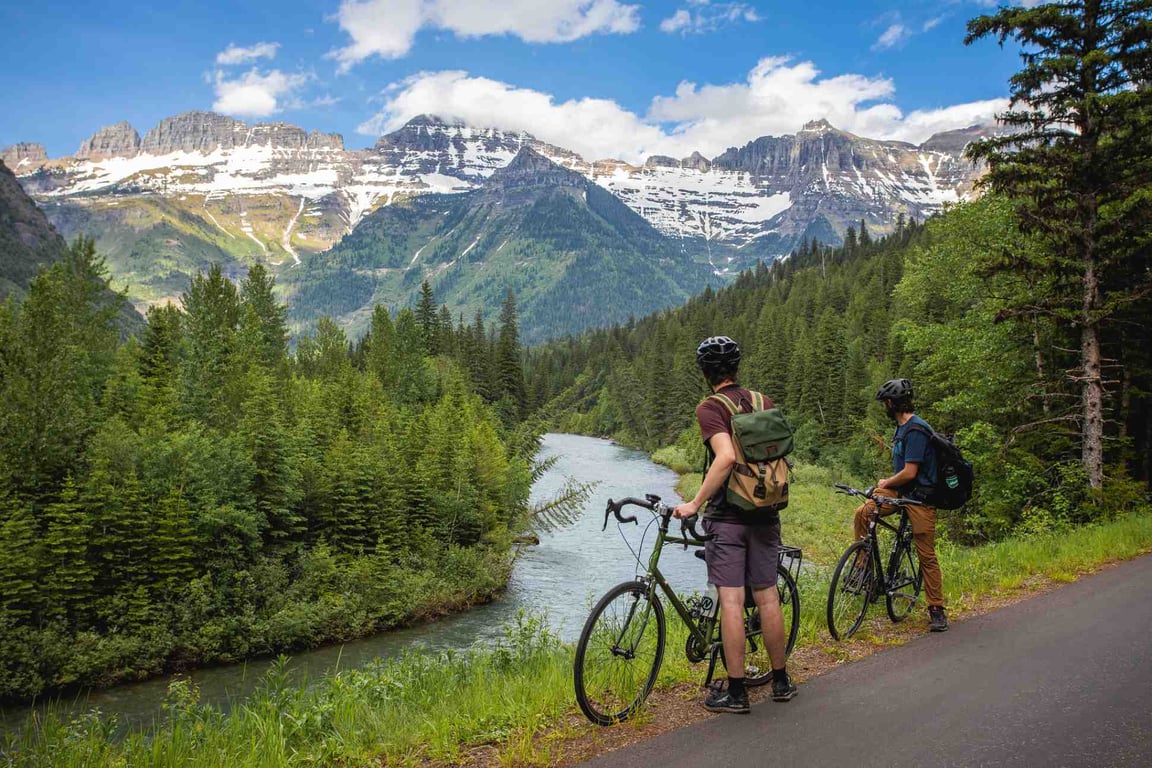 Cyclists overlooking a creek in Glacier National Park