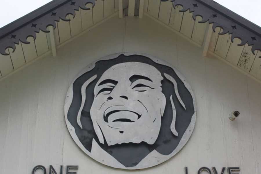 A striking black-and-white Bob Marley mural, spreading the message of "One Love" on a charming rooftop.