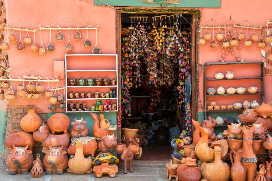 A colorful market filled with handcrafted pottery, trinkets, and traditional decorations invites you to explore its treasures.