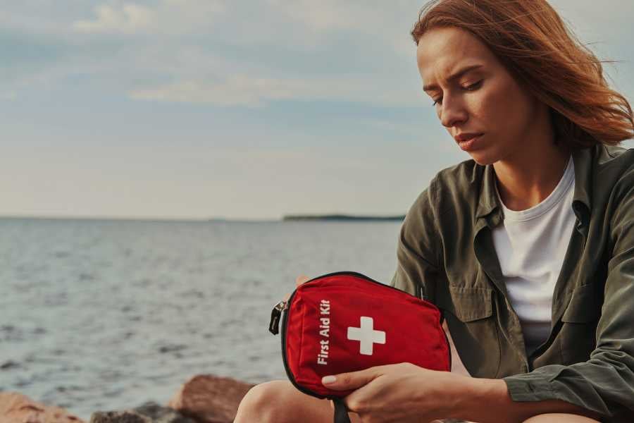 A woman is holding a first aid kit in her hands