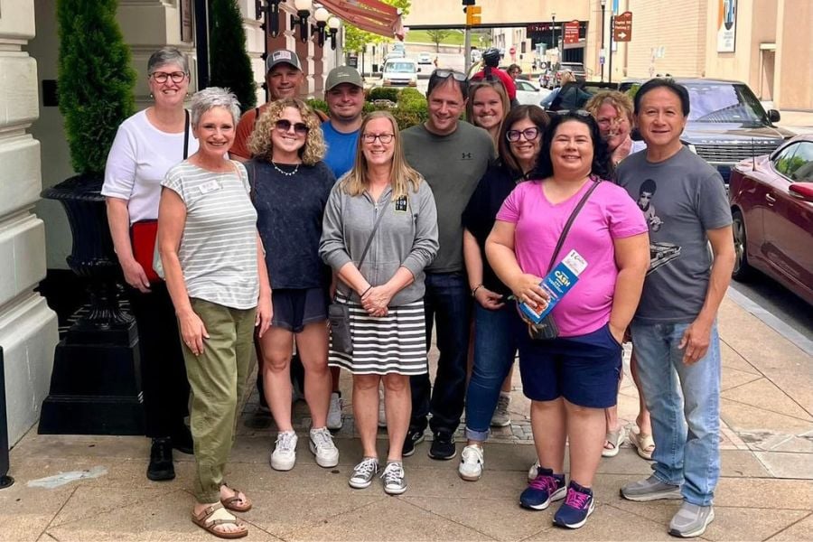 A happy group gathers outside, ready to explore the city together.