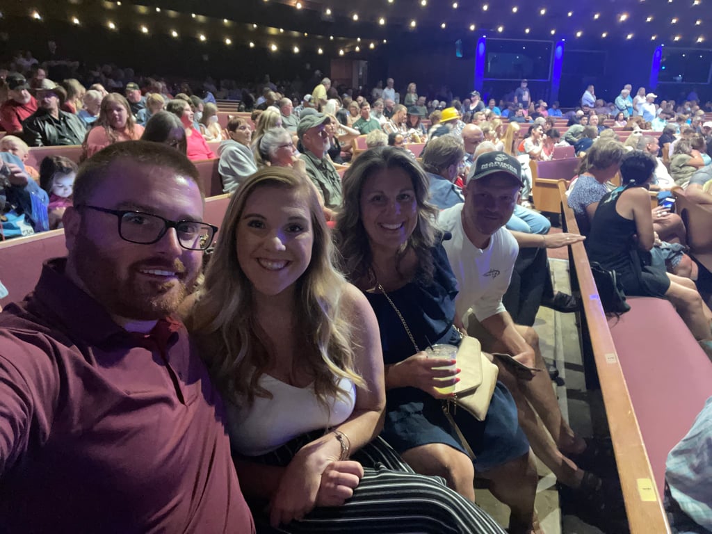 Visitors snap selfies and smile at the famous Grand Ole Opry.