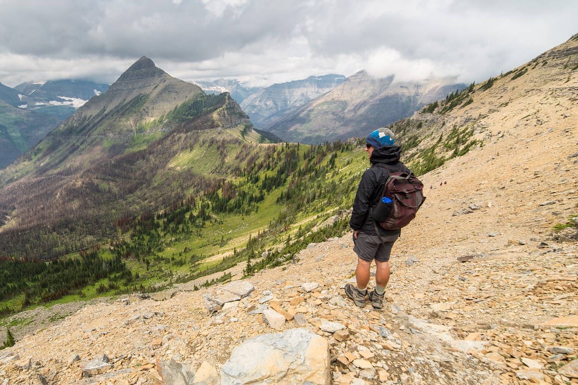 man in jacket and hiking boots on ridge